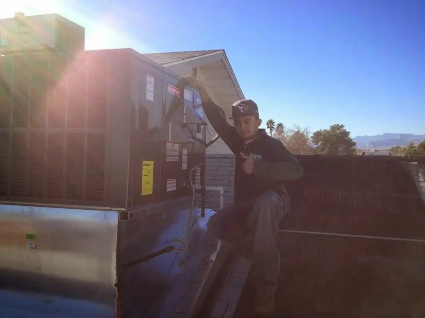 HVAC technician performing AC Tune-Up on a rooftop unit in Florida Ridge